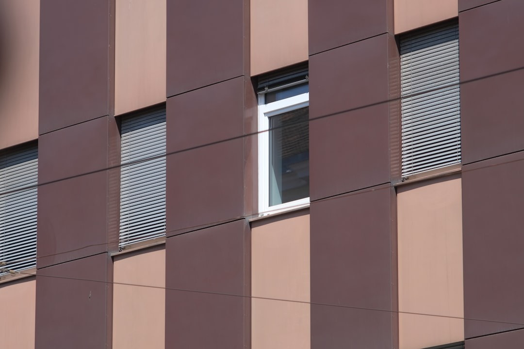 Modern building facade featuring a grid of brown and beige panels.
