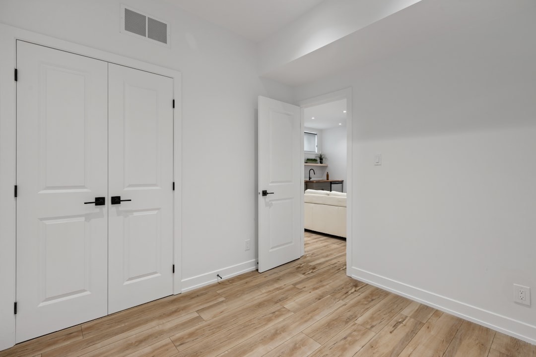 Empty room with light wood floors and open doorway.