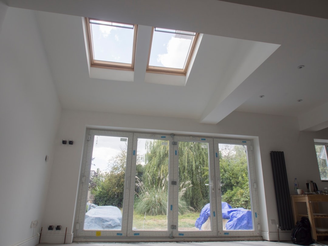 Renovating a bright room with bi-fold doors opening to greenery.