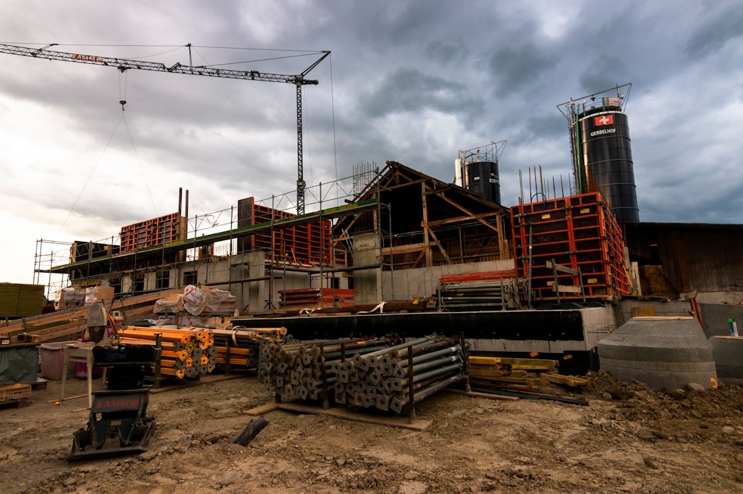 Construction site with crane and concrete foundations.
